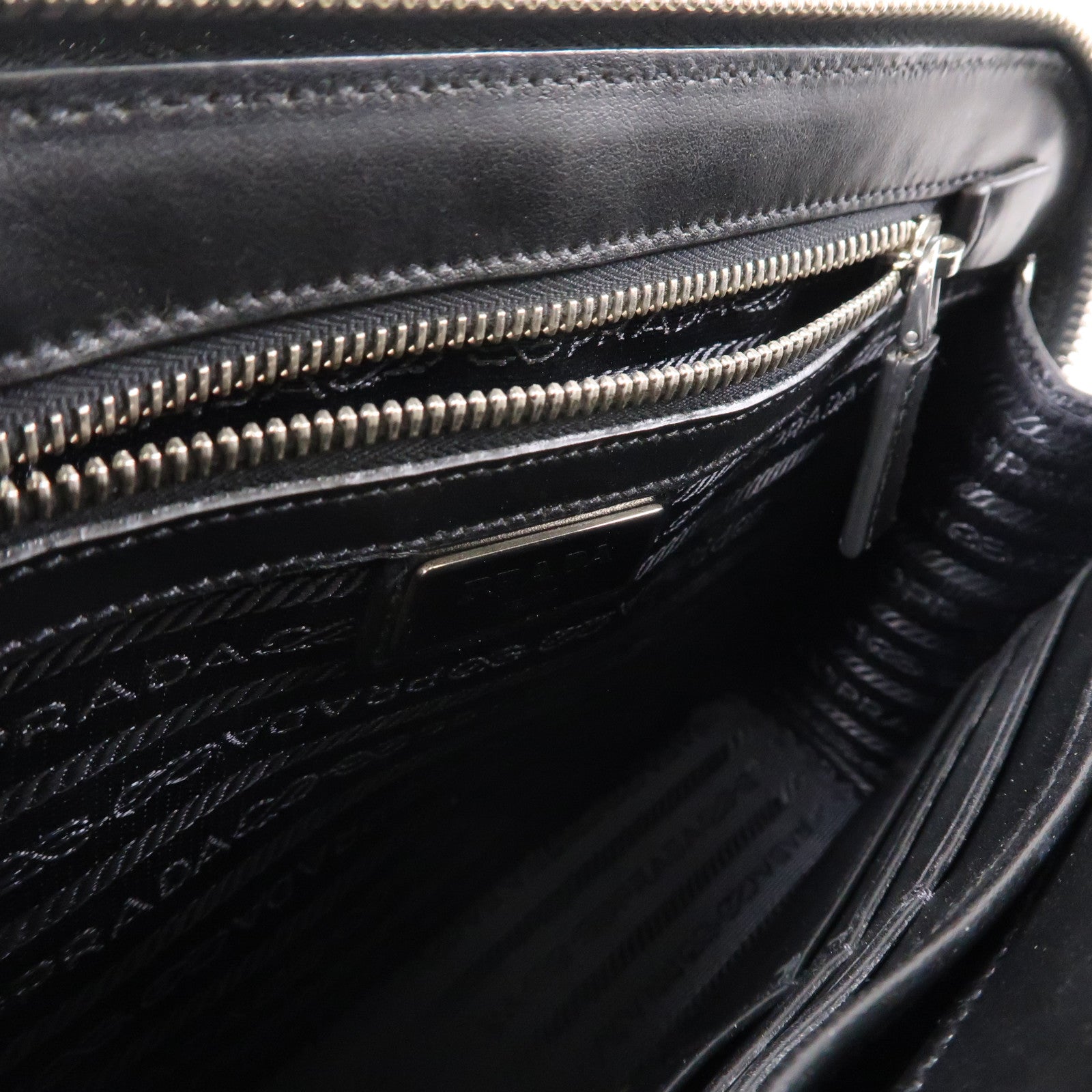 PRADA 牛皮皮革Saffiano Travel銀扣手拿包黑色