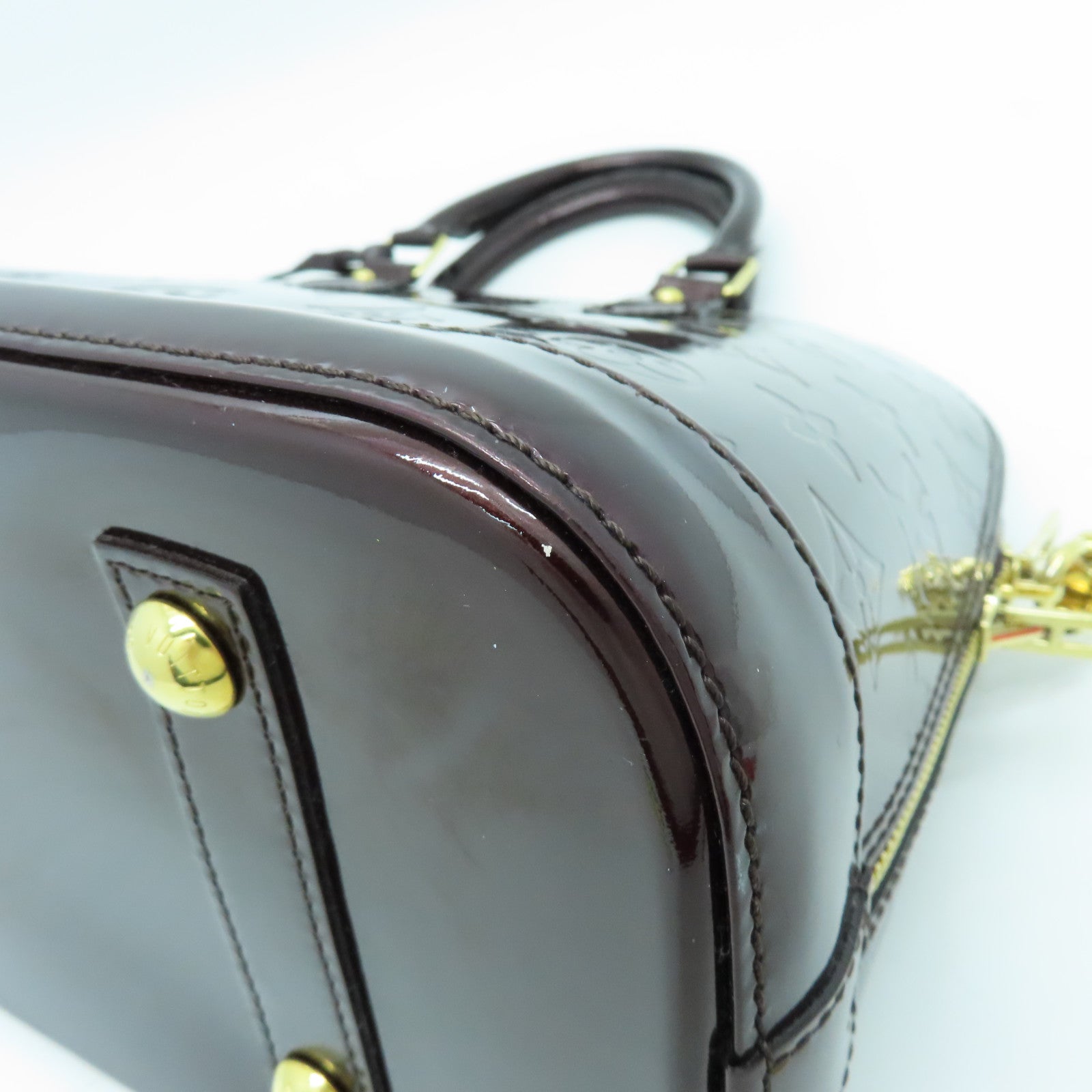 LOUIS VUITTON Monogram Vernis Alma PM gold buckle handle bag crimson