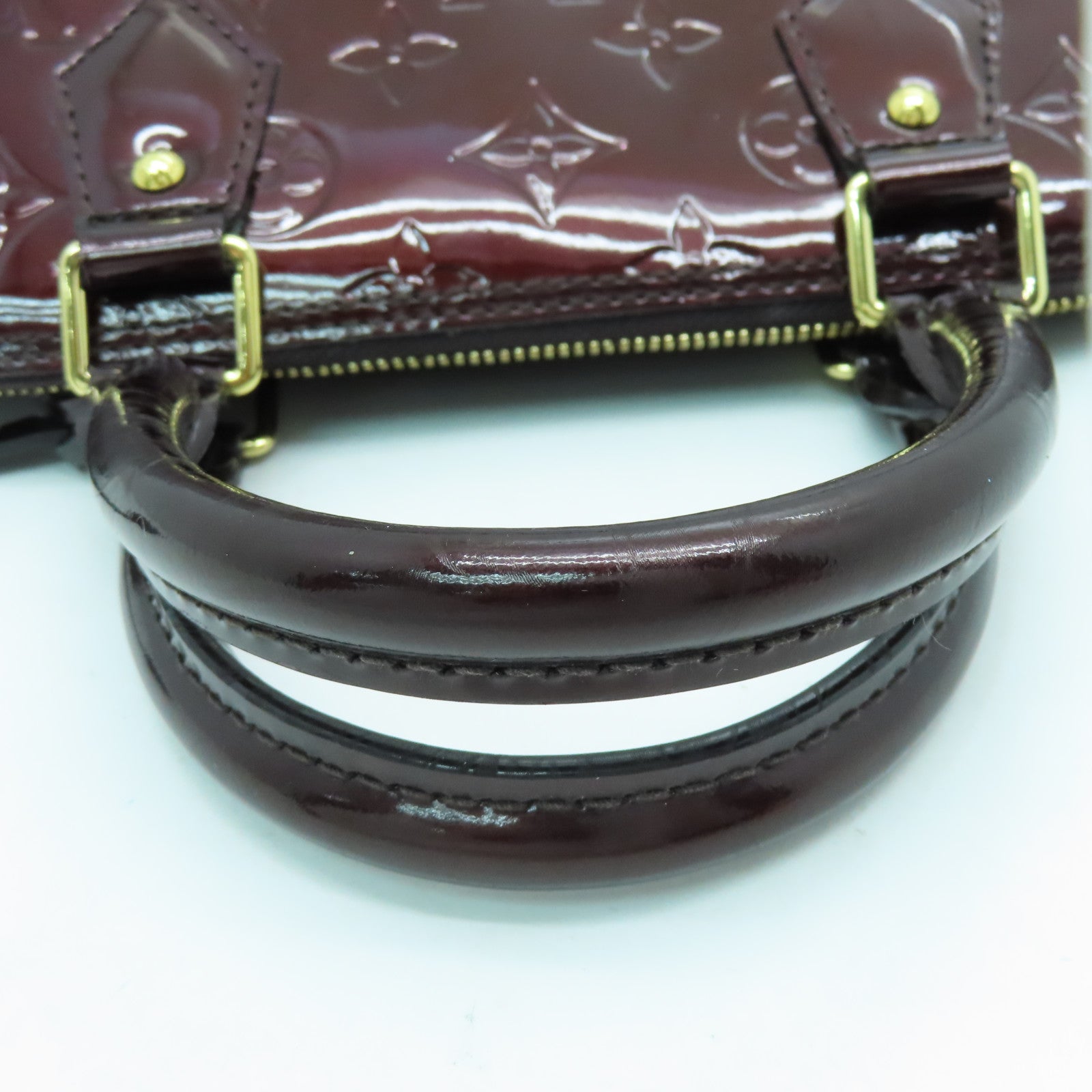 LOUIS VUITTON Monogram Vernis Alma PM gold buckle handle bag crimson